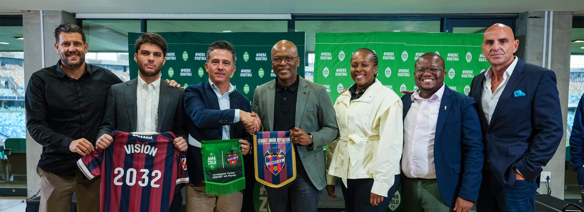 Representatives from AmaZulu FC, Levante UD and ISAM360 pose together with commemorative shirts and scarves at the partnership announcement.