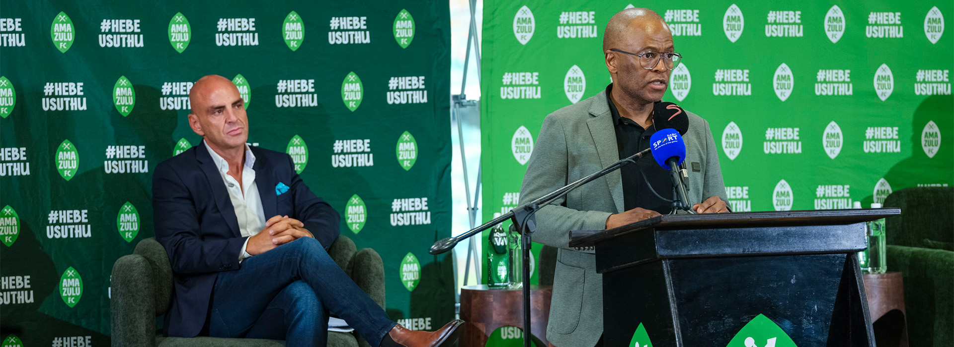 Sandile Zungu addresses the media from the podium while ISAM360 CEO Marcos Maisano looks on.